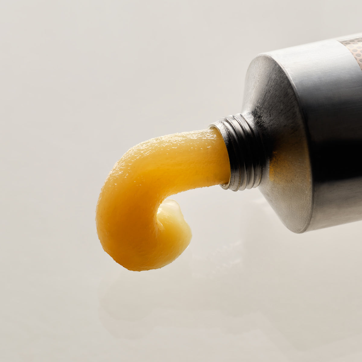 Gylden balm presset ud af en sølvfarvet tube fra ECOOKING Alt i én balm – balm til meget tør hud, tørre læber, hænder og hæle